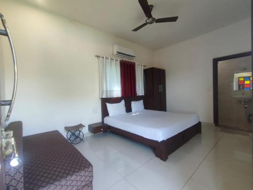 a bedroom with a bed and a ceiling fan at Aloha Farm & Camp in Udaipur