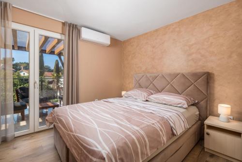 ein Schlafzimmer mit einem Bett und einem großen Fenster in der Unterkunft Villa Ivona with heated pool in Rovinj in Rovinj