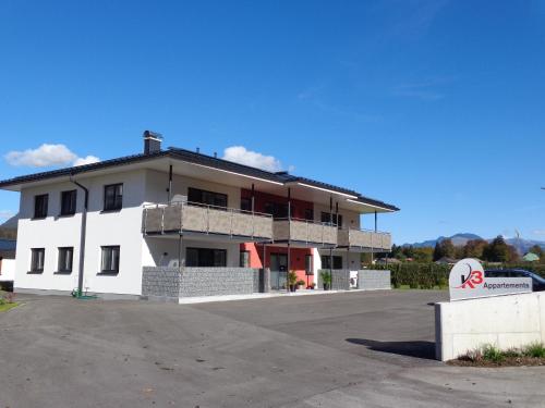 a white building with a parking lot in front of it at K3 - Appartements in Strobl