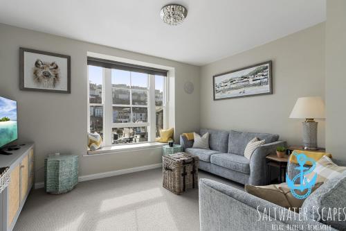 sala de estar con sofá y ventana en La Petite Maison Apartments en Brixham