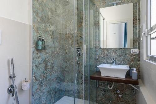 a bathroom with a shower with a sink and a mirror at Domus Angioina in Naples