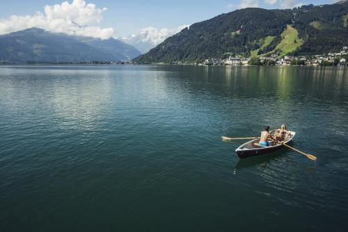 two people in a row boat on a lake at AlpenParks Chalet & Apartment AreitXpress in Zell am See