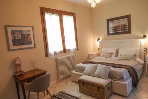 a bedroom with a bed and a chair and a window at La Corte del Pratello in Bologna