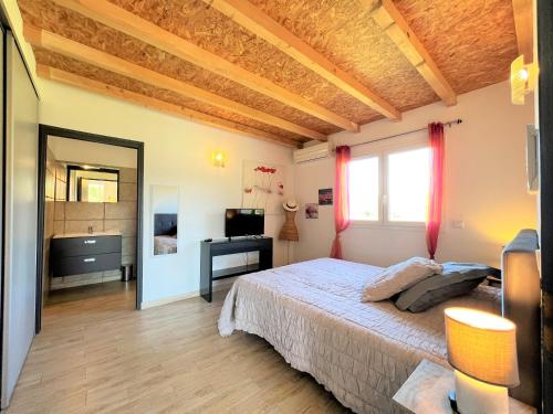 sypialnia z łóżkiem, biurkiem i oknem w obiekcie La villa Thomas avec piscine chauffée, classée 4 étoiles w mieście Serra-di-Ferro