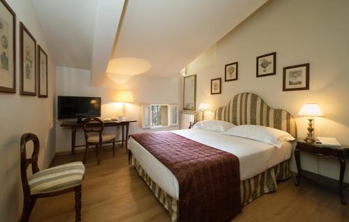 a hotel room with a large bed and a desk at Park Palace Hotel in Florence