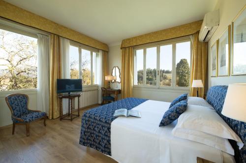 a bedroom with a bed and two windows at Park Palace Hotel in Florence