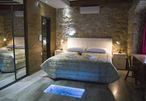 a bedroom with a large bed and a stone wall at Villa Domina in Split