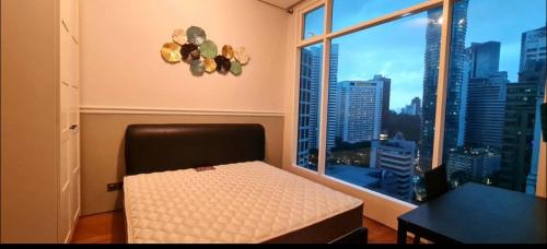 - une chambre avec un lit et une grande fenêtre dans l'établissement 3ROOMS SOHO SUITES KLCC BY RED HOMES, à Kuala Lumpur