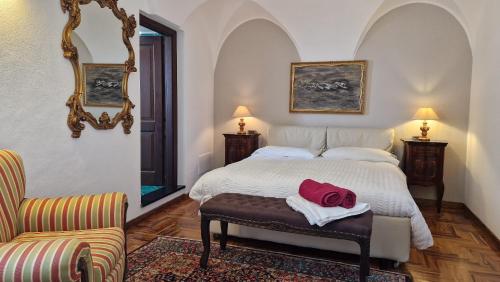 una camera da letto con un letto e un asciugamano rosso su uno sgabello di Maison Paradiso: Charme e relax a Pietra Ligure a Pietra Ligure