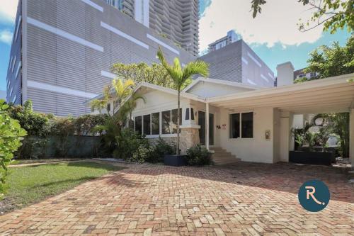 a white house with a brick driveway at Roami at Villa Bella in Miami