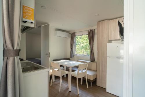 a small kitchen and dining room with a table and chairs at Romea Family Camping in Casal Borsetti