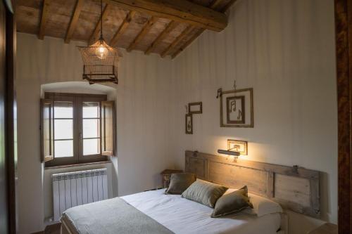 a bedroom with a bed with white sheets and a window at La Casa Di Campagna in Magione