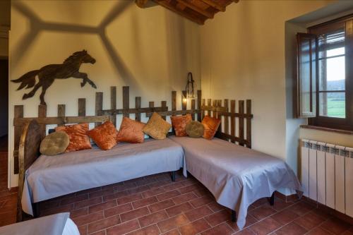 two beds in a bedroom with a horse on the wall at La Casa Di Campagna in Magione