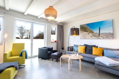 een woonkamer met een blauwe bank en gele stoelen bij Ferienhaus Seeherz in Ostseebad Sellin
