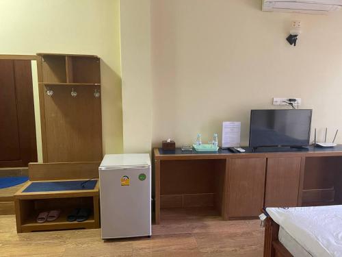a room with a desk with a refrigerator and a tv at BLUE SKY GUEST HOUSE in Phnom Penh
