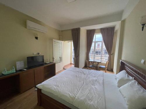a bedroom with a large bed and a television at BLUE SKY GUEST HOUSE in Phnom Penh