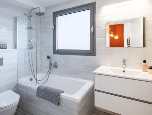 La salle de bains est pourvue d'une baignoire, d'un lavabo et de toilettes. dans l'établissement Beach & Market Designed Duplex, à Tel Aviv
