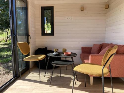 een patio met een bank en een tafel en stoelen bij Joy Tiny House Perche in Madeleine