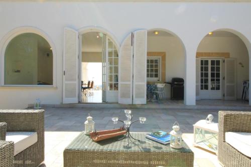 - un salon avec une table, des chaises et des fenêtres dans l'établissement La Perla Bianca, à Gagliano del Capo
