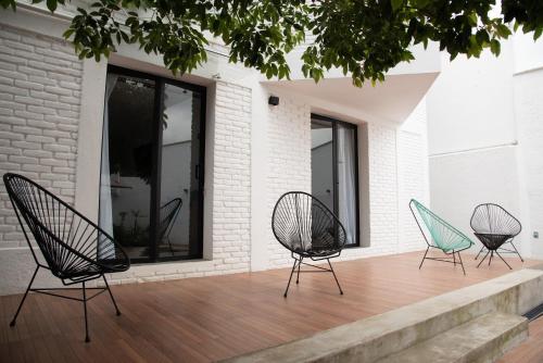 four chairs sitting on a deck next to a building at Casa Naâmja in Tepoztlán