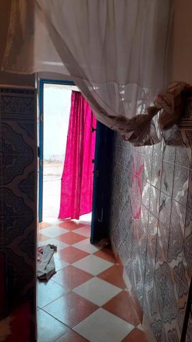uma porta aberta para um quarto com uma cortina vermelha em Bedouza Paradise 