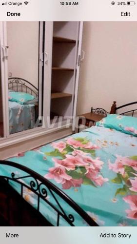 um quarto com uma cama com flores cor-de-rosa em Bedouza Paradise 