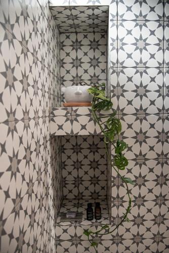 a bathroom with a white and gray tiled wall at Casa Naâmja in Tepoztlán
