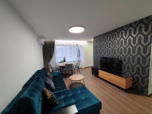 uma sala de estar com um sofá azul e uma mesa em City apartment 2 bedrooms em Siauliai