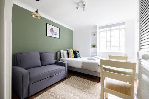 una camera con letto, divano e sedia di The Bayswater Studio a Londra