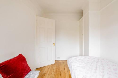 a bedroom with a white bed and a red pillow at Littlehaven in Roffey