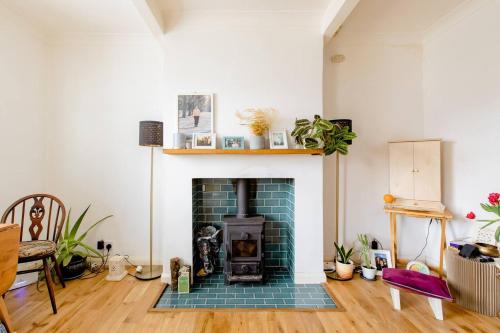 a living room with a fireplace with a green brick at Littlehaven in Roffey