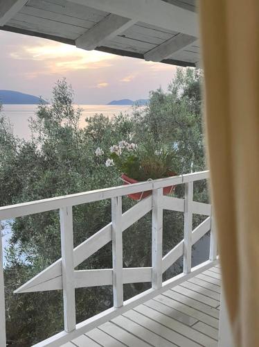 a porch with a white fence and a view of the water at Marios Rooms in Vlorë