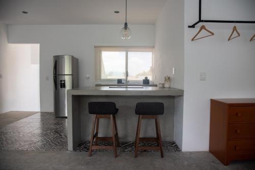 a kitchen with two bar stools and a sink at Casa Naâmja in Tepoztlán