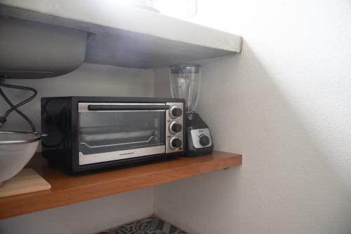 a microwave sitting on a shelf next to a blender at Casa Naâmja in Tepoztlán