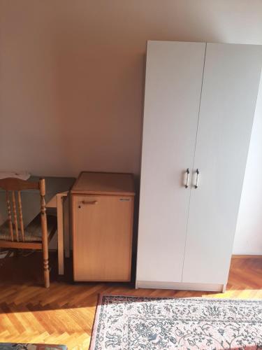 een kamer met een witte kast en een tapijt bij Magyar Csárda és Vendégház in Harkány