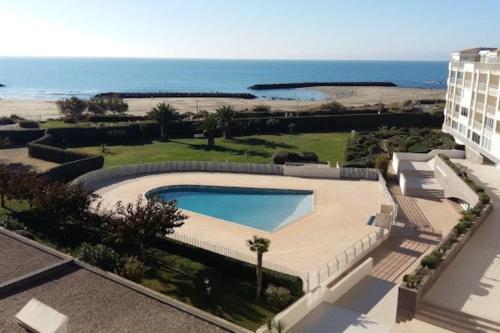 - une vue sur la piscine et la plage dans l'établissement Appartement face à la mer, au Cap d'Agde