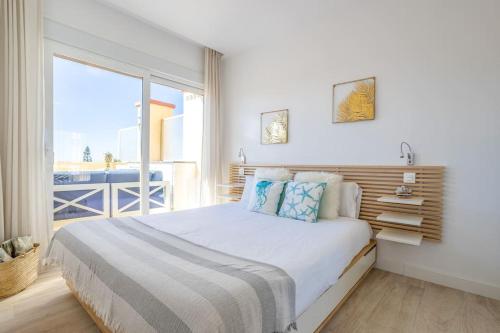 OleHolidays 535 Romana Playa con vistas al mar في مربلة: غرفة نوم بسرير كبير مع نافذة كبيرة