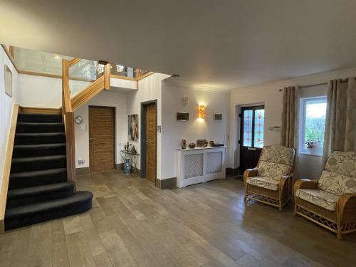 a living room with a staircase and two chairs at The Waters Edge Guest House in Stratford-upon-Avon