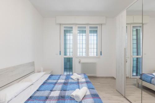 a white bedroom with a large bed and a mirror at Gobetti, Bologna by Short Holidays in Bologna