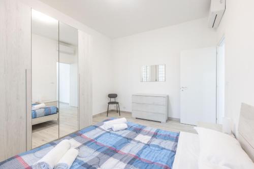 a white bedroom with a bed and a mirror at Gobetti, Bologna by Short Holidays in Bologna