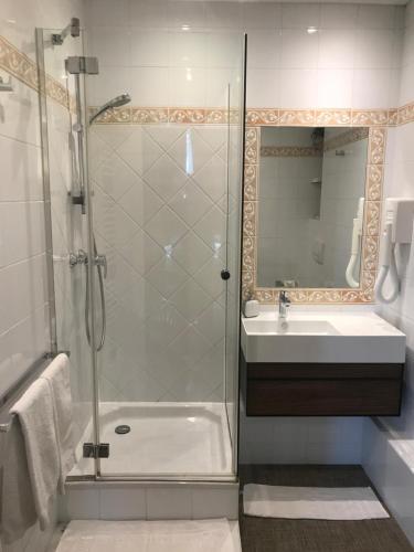 a bathroom with a shower and a sink and a mirror at Clos Saint Nicolas in Neauphle-le-Château