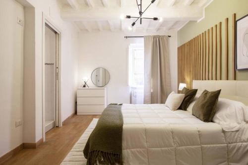 a white bedroom with a large bed and a mirror at Elegant flat in the city centre with two suite in Perugia