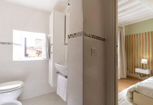 a white bathroom with a toilet and a sink at Elegant flat in the city centre with two suite in Perugia