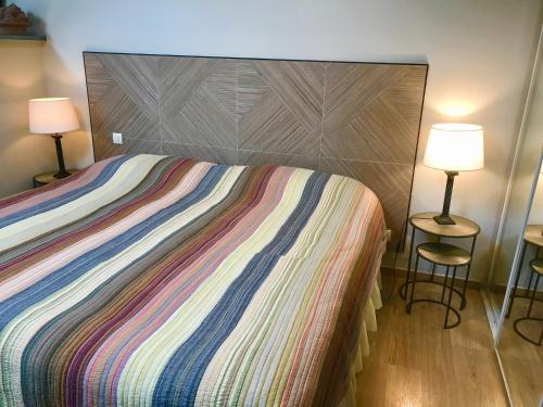 a bedroom with a large bed with two lamps at Clos Saint Nicolas in Neauphle-le-Château