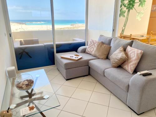 - un salon avec un canapé et une vue sur la plage dans l'établissement Terra Kriola, à Sal Rei