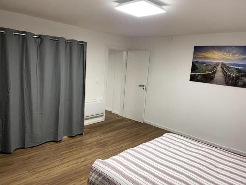 a bedroom with a bed and a window with curtains at Apartament cozy in Villerupt