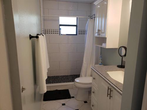 a bathroom with a shower and a toilet and a sink at Venice Gardens, 2-Br Pet Friendly Home - Indra in Venice