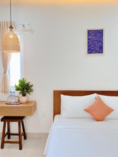 a bedroom with a bed and a table with a potted plant at Tuna Hotel Phú Yên in Liên Trì (3)