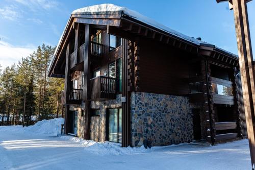 une cabane en rondins sous la neige dans les bois dans l'établissement Levi Platinum Superior Apartments, à Levi