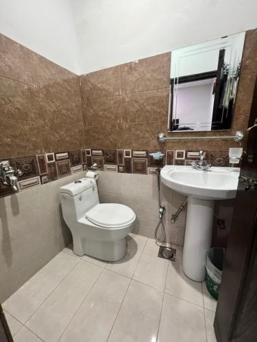 a bathroom with a toilet and a sink at Al Atif Guest House in Islamabad